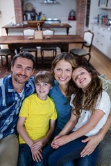 Wall Mural - Portrait of happy family sitting on a sofa