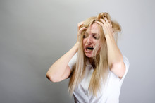 Young Woman Screaming From Pain And Holding Her Head