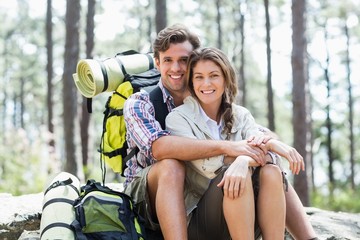 Wall Mural - Portrait of smiling couple sitting on rock 