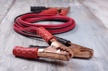 Automotive jumper leads isolated on the wooden background