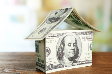 Money house on wooden table, close up