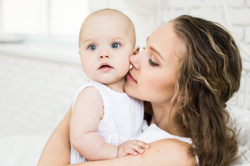 happy family. mother playing with her baby in the bedroom.