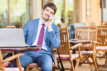 Successful man hands up outdoor at cafe