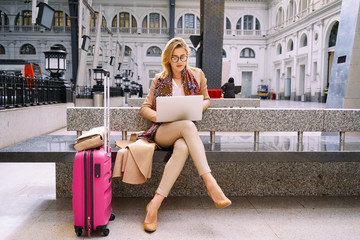 beautiful female freelancer using a laptop for distance work while waiting for the train.modern business woman checks e-mail on a laptop computer before the go on vacation