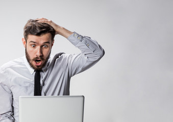 The young surprised man with his laptop computer