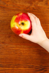 Wall Mural - children holding red apple. Top view. vertical shot