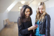 © Johnér - Female friends using smartphone indoors