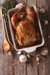 Canvas Print - French Food: Chicken with 40 cloves of garlic in the dish for baking close-up. Vertical top view
