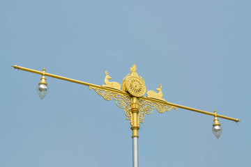 statue of native thai art with street lamps on blue sky backgrou