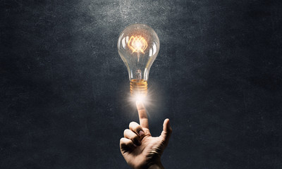 Wall Mural - hand pointing light bulb