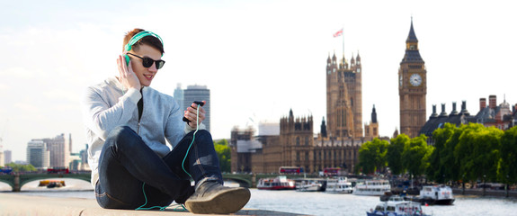 happy young man in headphones with smartphone