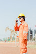 man holding walkie-talkie radio in hand, communication in oil field site