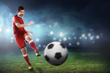 Fototapeta Sport - Asian football player kick ball