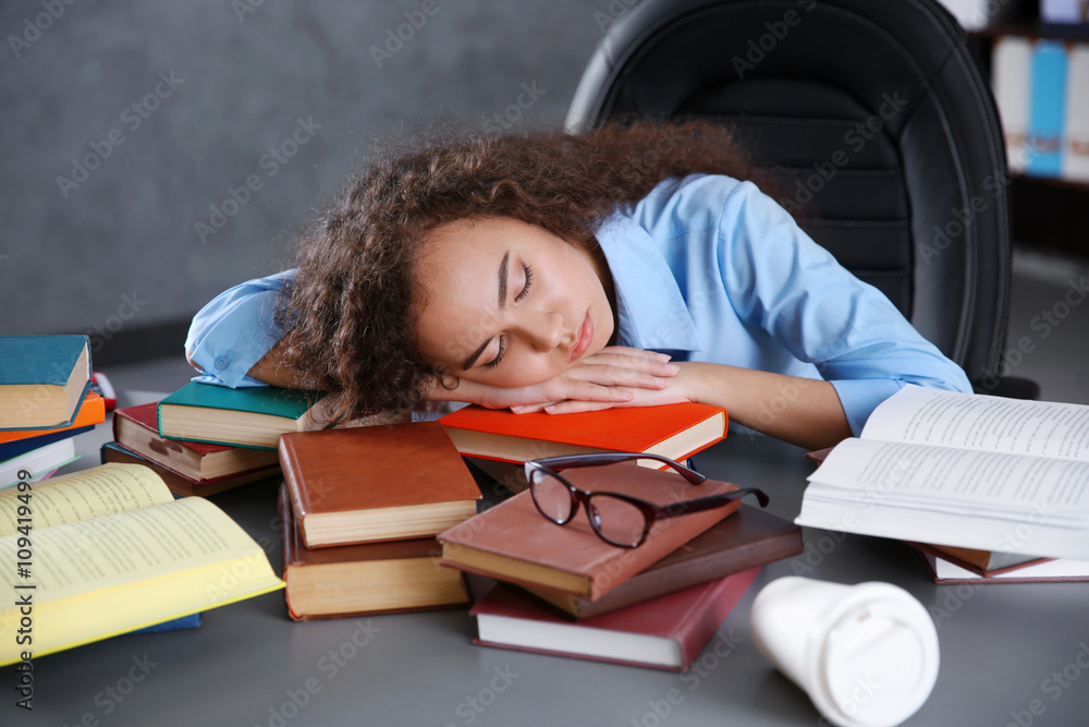 Tired beautiful girl sleeping on table