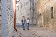 © Acronym - Young couple walking down a medieval street