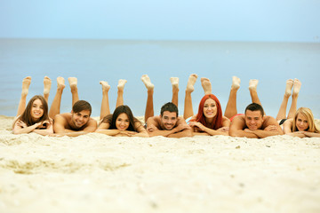 Wall Mural - Beautiful young people lying on beach