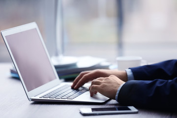 Man's hands using laptop at the table