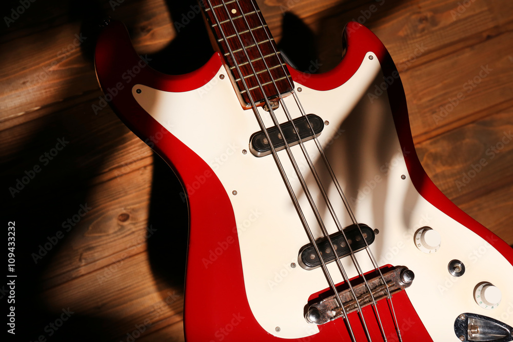 Electric guitar with shadow hand on wooden background