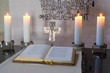 Altarraum mit Bibel, Kreuz und brennenden Kerzen, sakral, andächtig,  Szene, warmes Licht brennender Kerzen