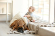 © Africa Studio - Little baby boy with boxer dog resting near window at home