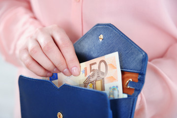 Sticker - Female hands holding leather purse with euro banknotes closeup