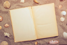Top View Of Open Book On Sandy Beach