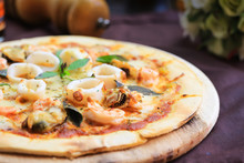 Delicious Pizza With Seafood On Wooden Stand.