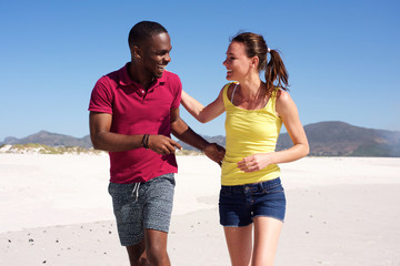 Wall Mural - Happy young fitness couple walking together on beach