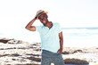 © mimagephotos - Cool young guy with hat smiling at the beach