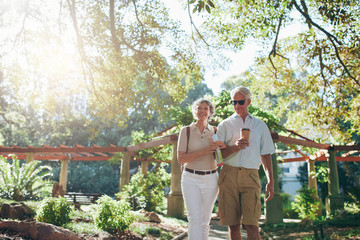 Wall Mural - Couple of tourist walking through a park