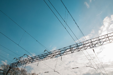 High-voltage power transmission on background blue sky with clouds