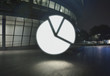© Connect Images - Glowing pie chart symbol in city at night