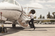 © Connect Images - Male private jet pilot boarding plane at airport