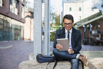 Young asian man looking at digital tablet