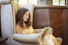 Woman Reading Book In Old Armchair