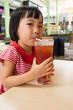 Leinwandbild Motiv Asian Little Chinese Girl Drinking Ice Tea