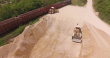 Excavators At Work. Pile Of Gravel And Stones At The Depot. Aerial Over Earth Moving Machines Loading Gravel And Stones From The Pile