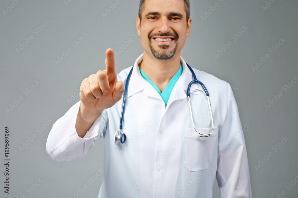 Portrait of a doctor with stethoscope on grey background