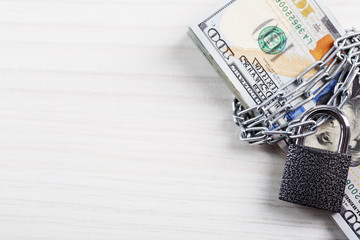 Wall Mural - Dollars currency with lock and chain on wooden table background