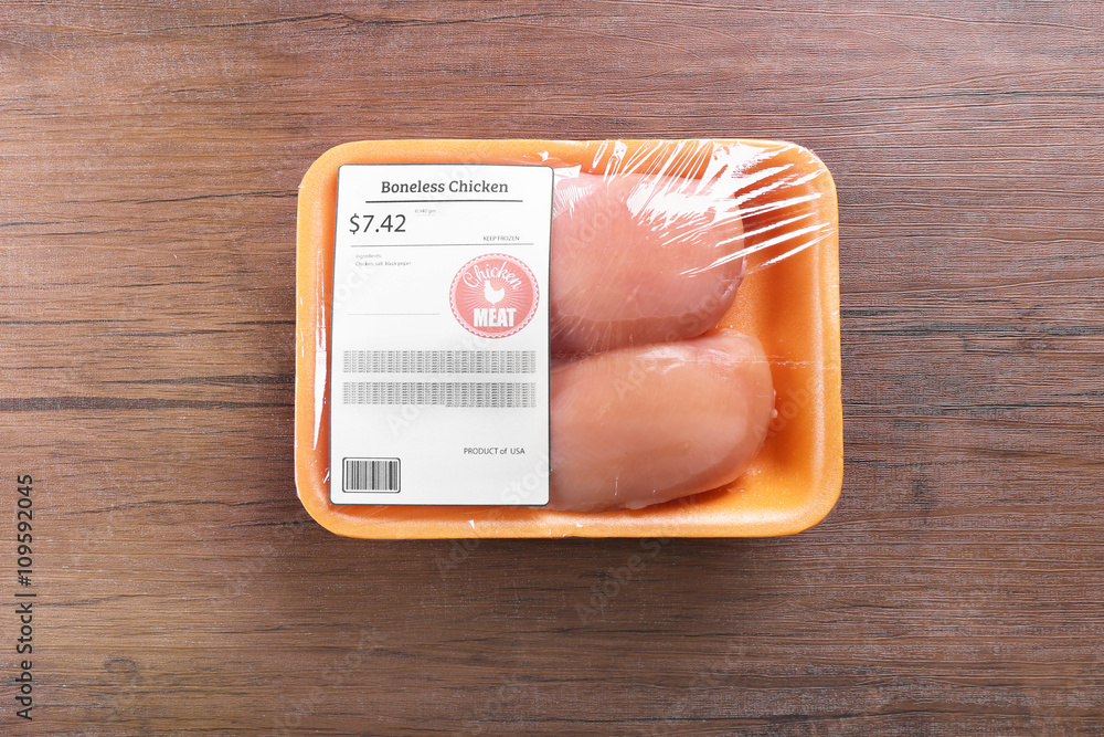 Packed pieces of chicken meat on wooden background