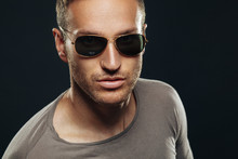 Handsome Man Wearing Sunglasses In The Studio On A Dark Backgrou