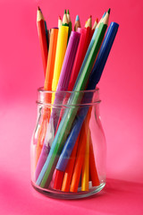 Wall Mural - Colorful stationery in glass jar on pink background