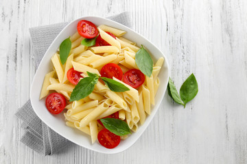 Poster - Plate of pasta with cherry tomatoes and basil leaves on wooden table, top view