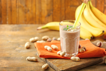 Wall Mural - Fresh banana cocktail with peanuts on wooden table