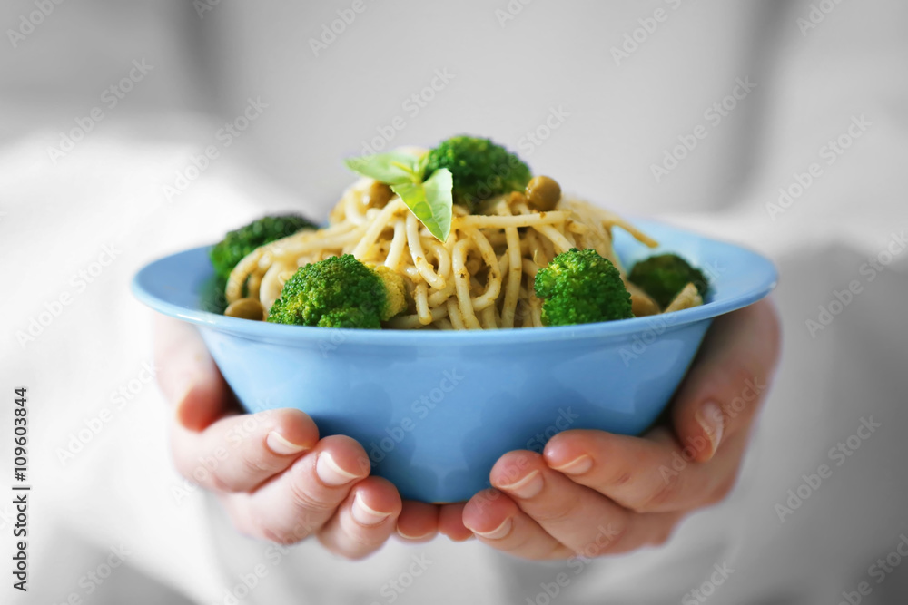 Chef hands holding delicious cold pasta salad in bowl closeup