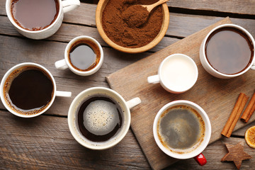 Wall Mural - Cups of coffee with spices on wooden table, top view