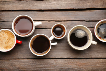 Sticker - Different cups of coffee on wooden table, top view