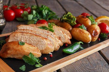 Chicken breast baked with tomato new potatoes and broccoli