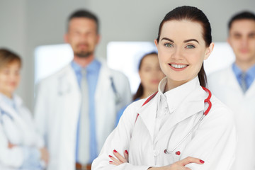 Sticker - Smiling doctor with medical workers standing in hospital