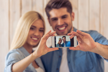 Canvas Print - Beautiful young couple with gadget